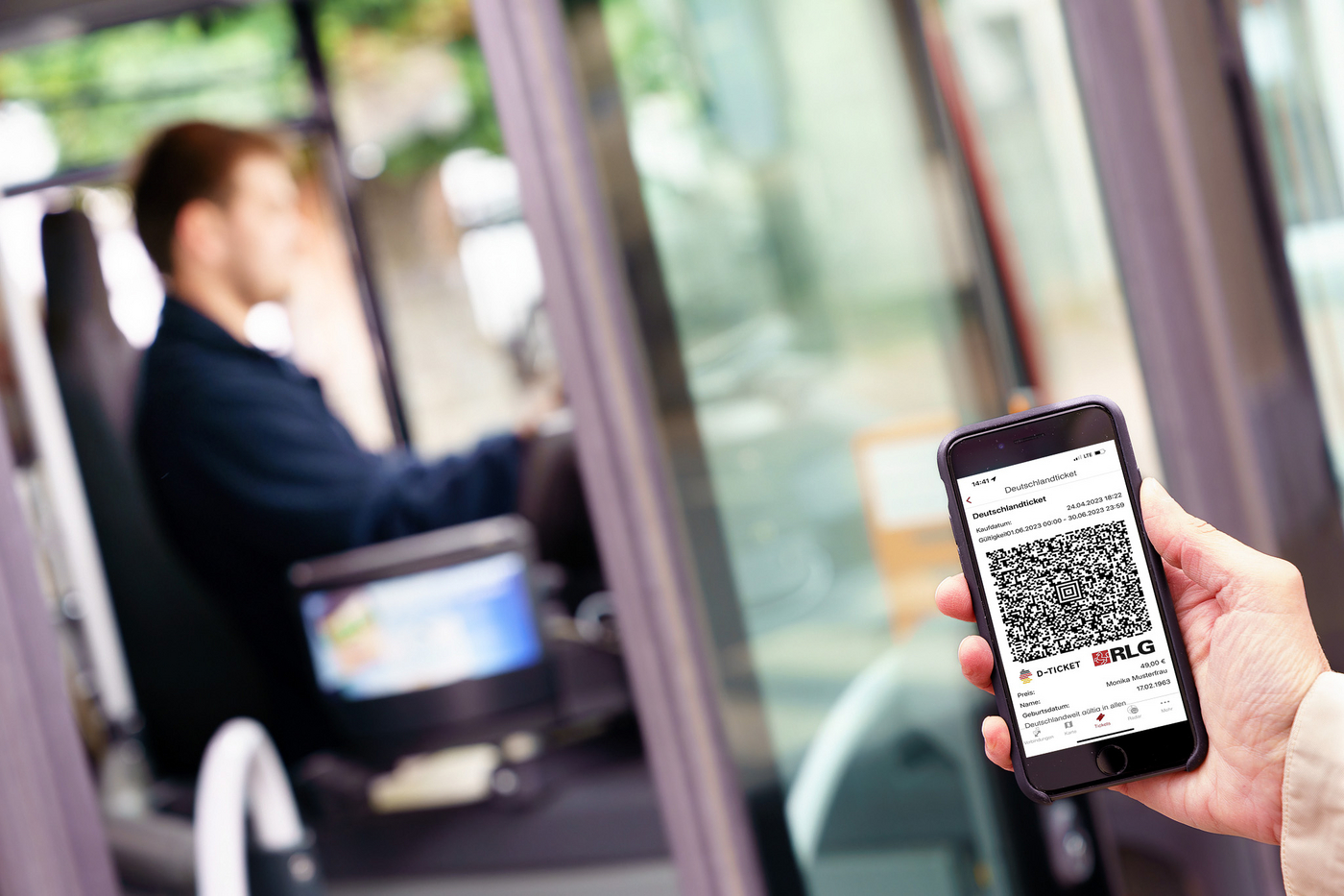 Handy mit Screenshot Deutschlandticket wird beim Einstieg in den Bus gezeigt