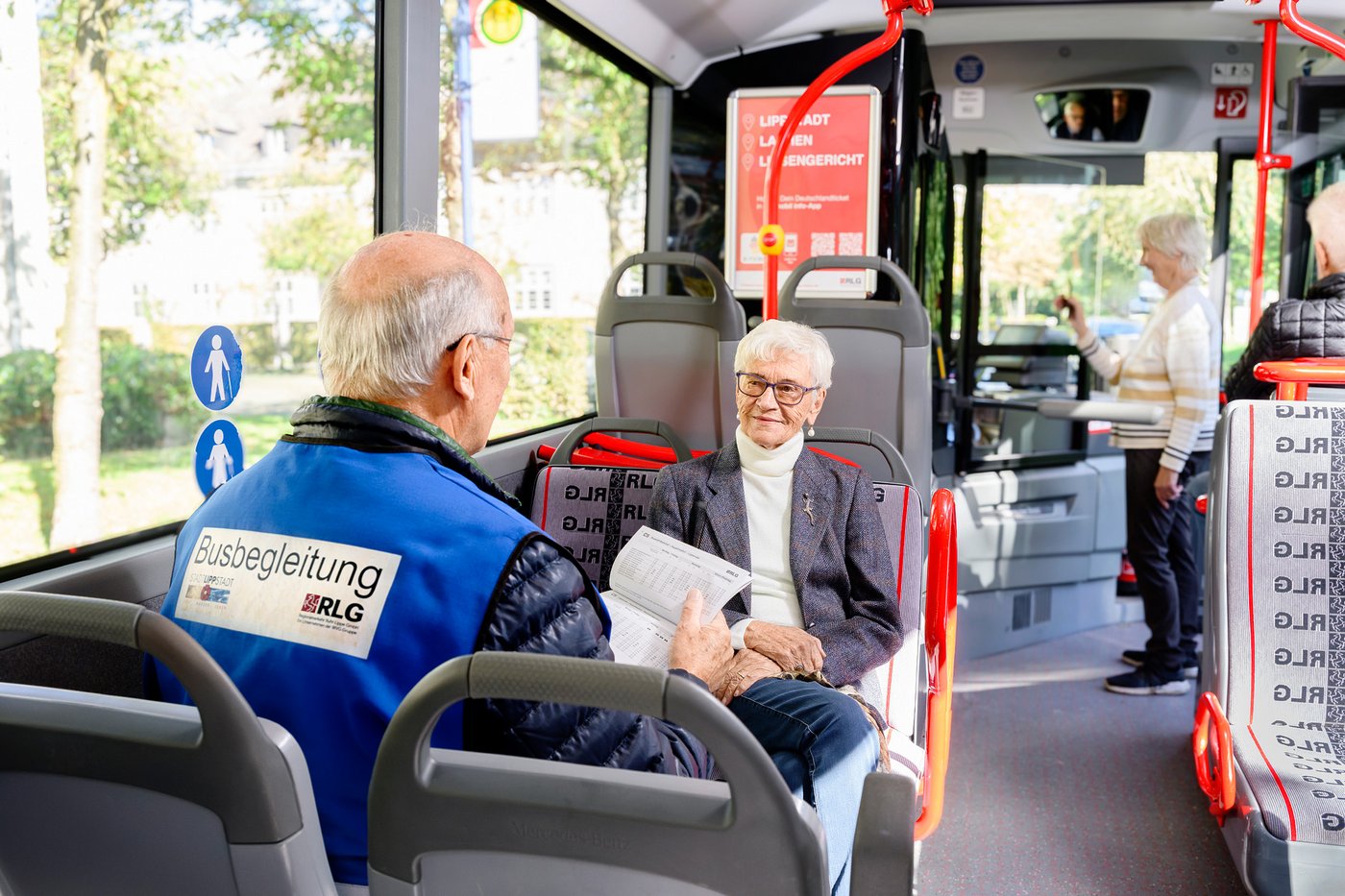 Busbegleiter mit Fahrgast im Bus