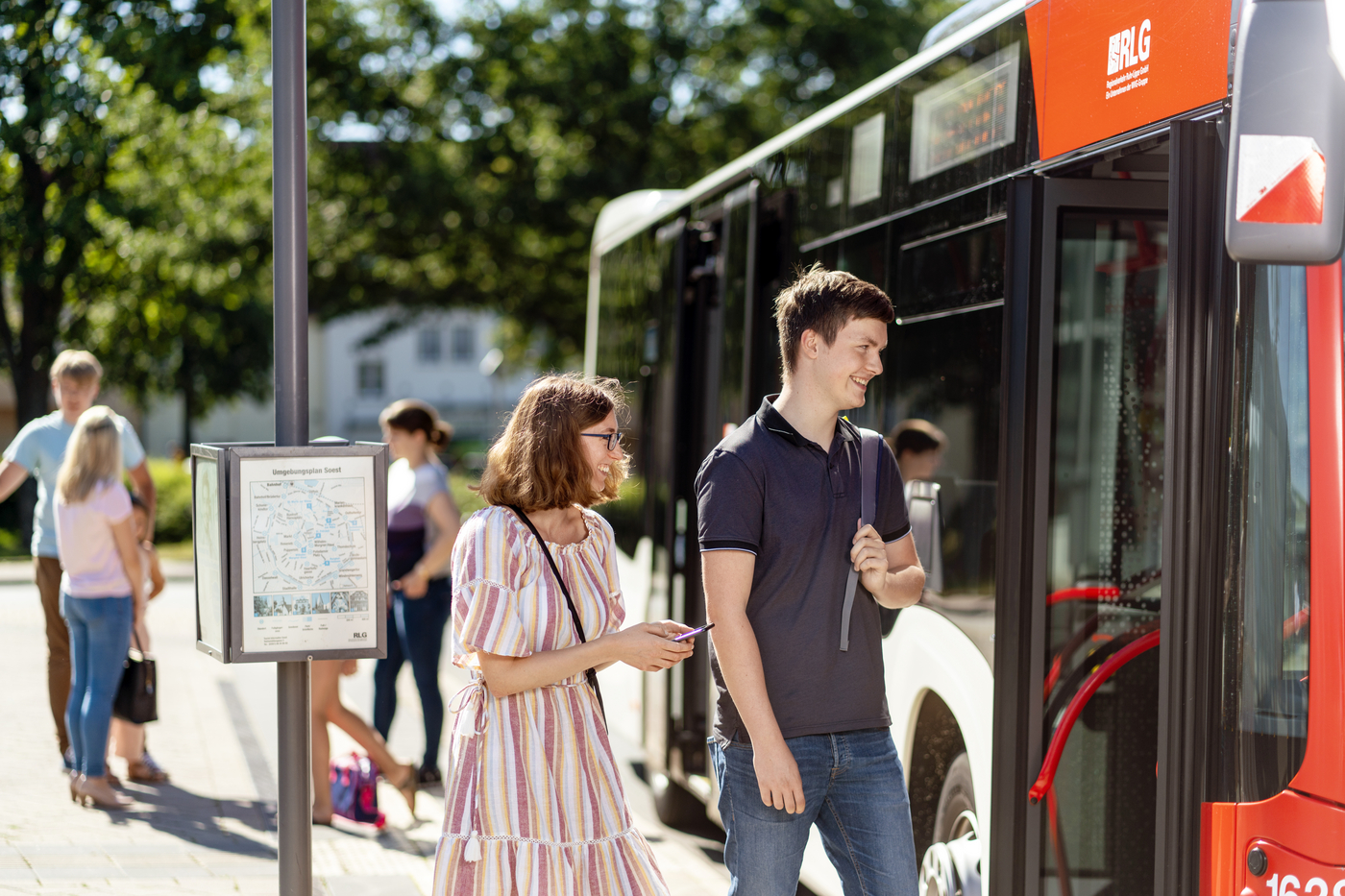 Zwei Personen steigen vorne in den Bus ein.