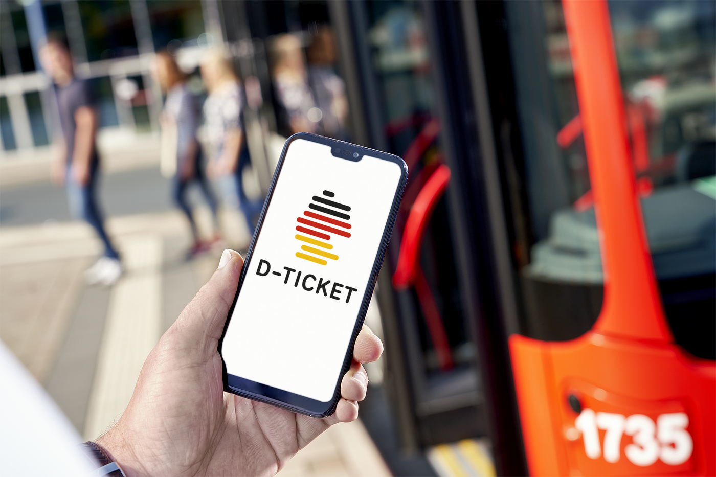 Hand mit Smartphone. Bildschirm zeigt Deutschlandticket
