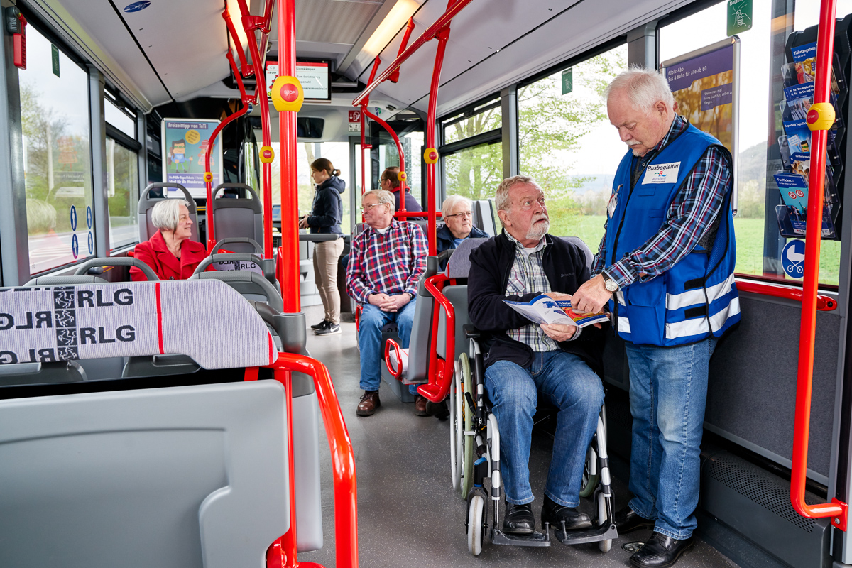 Mann begleitet Rollstuhlfahrer im Bus